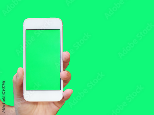 Hand hold smartphone with green screen in coffee shop concept for app promotion