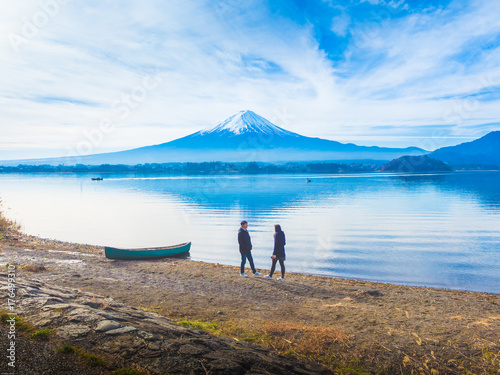 silhouette asia couple traveler 30s to 40s relax and talk at side of lake kawaguchi on morning time with fuji mountain background