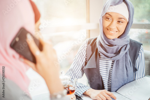 Muslim Woman On Break Using Mobile Phone In cafe photo