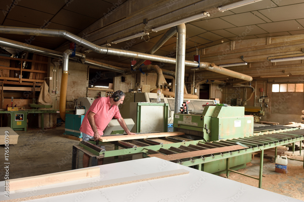 Fototapeta premium carpenter polishing wood in a carpentry workshop