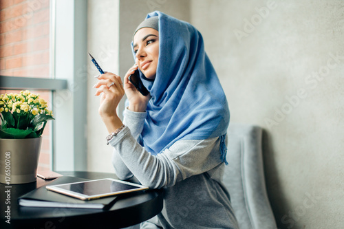 Muslim business woman on phone over conference photo