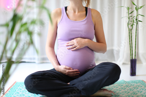 young woman touching her own pregnant belly