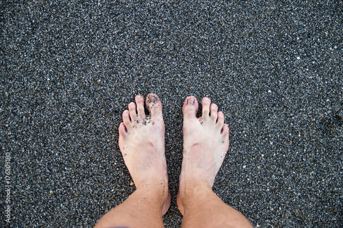 Legs against the background of sea pebbles