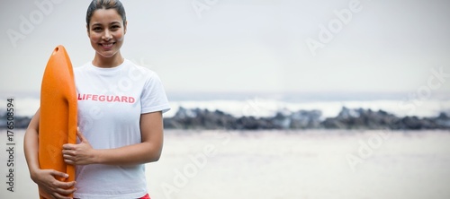 Composite image of portrait of female lifeguard holding rescue