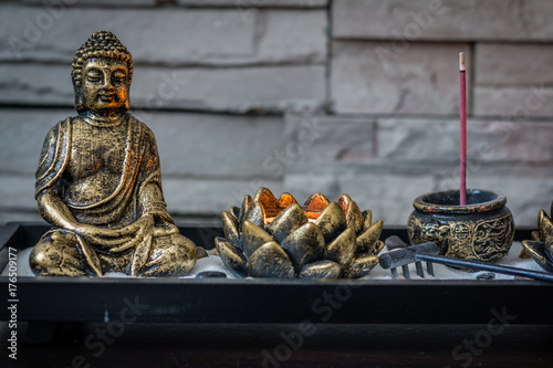 Mini, desk zen garden with lit candle and small Buddha in it photo