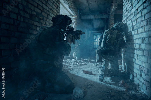 Special Forces soldiers in action. Elite squad sneak up to the enemy in a dilapidated building.They use special equipment, weapons and tactical devices.