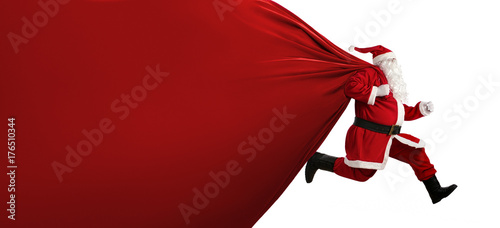 Santa Claus with huge bag, on the run, to delivery christmas gifts isolated on white background photo