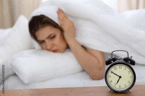 Wallpaper Mural Beautiful sleeping woman lying in bed and trying to wake up with alarm clock. Girl having trouble with getting up early in the morning, Nightmare Torontodigital.ca