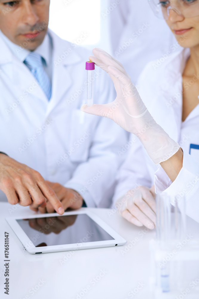 Team of scientific researchers in laboratory studying substances or blood sample. New vaccine for pharmacology industry is s almost ready. Medicine and science concept Team of scientific researchers in laboratory studying substances or blood sample. New vaccine for pharmacology industry is s almost ready. Medicine and science concept