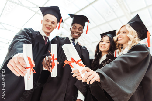 multiethnic students showing diplomas