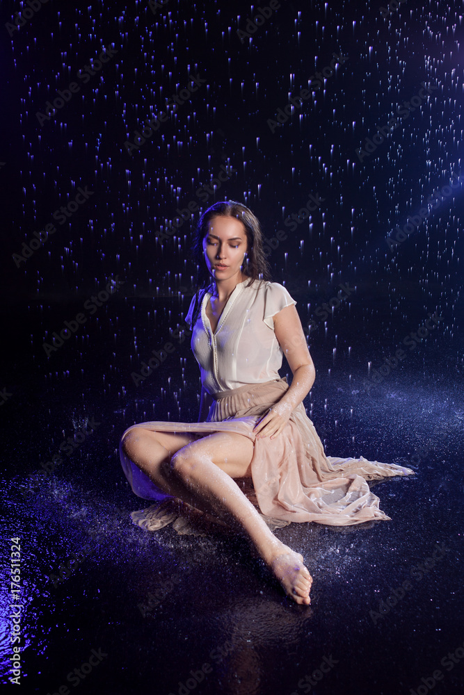 Girl sitting in the rain, night concept. Mystical style Girl sitting in the rain, night concept. Mystical style