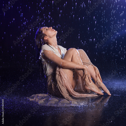 Girl sitting in the rain, night concept. Mystical style