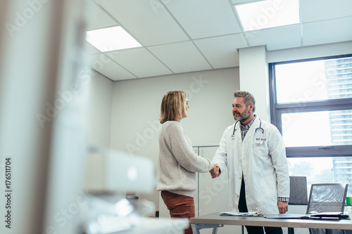 Physician shaking hands with patient in clinic