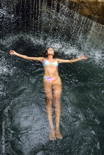 Young woman floating in water in pool with waterfall © Westend61