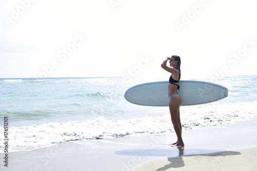 Woman at the ocean with surfboard