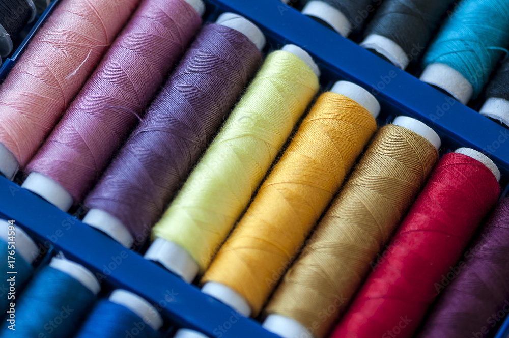 Close-up on colored sewing threads on spools Close-up on colored sewing threads on spools