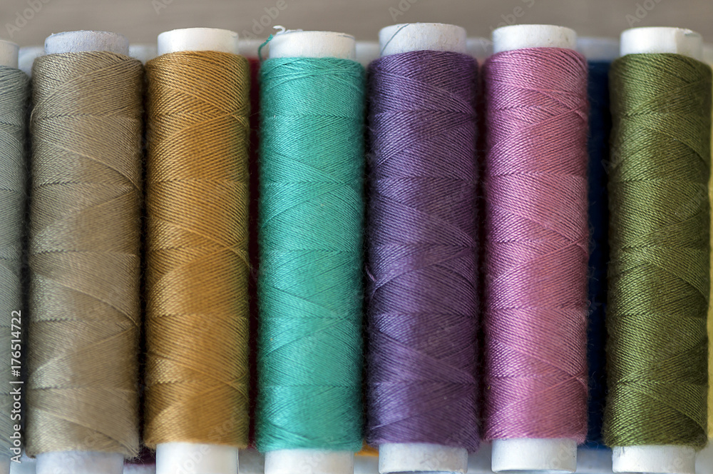 Close-up on colored sewing threads on spools Close-up on colored sewing threads on spools