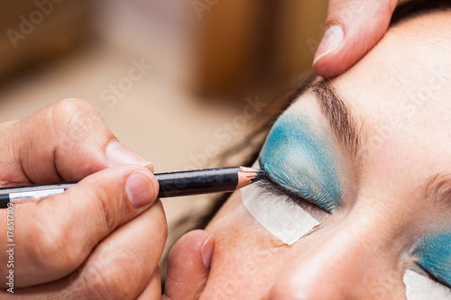 Make up artist using masking tape to create cat eyes