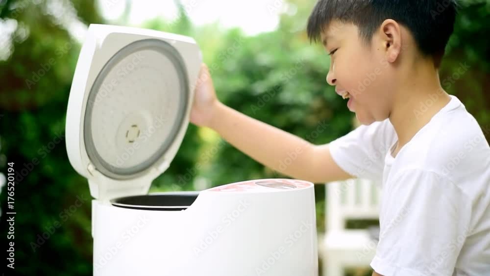 Preteen asian Thai boy and electric rice cooker that cooking a very ...