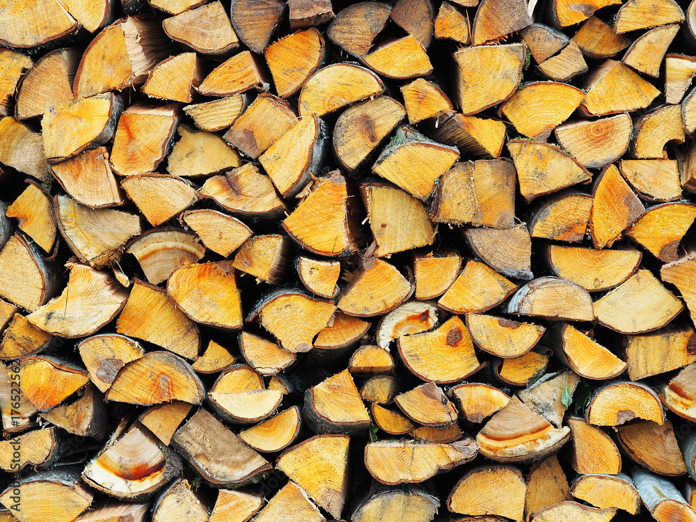 Woodpile of aspen and alder firewood, raw wood background. Natural rural stack of wood