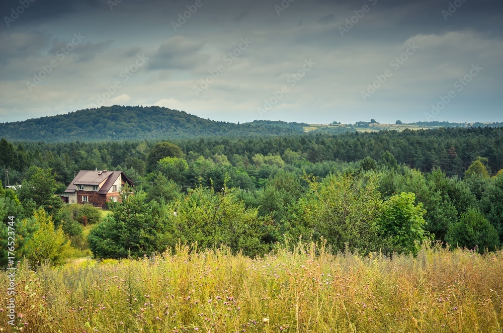 Cloudy rural landscape. Country house among the green hills. Cloudy rural landscape. Country house among the green hills.