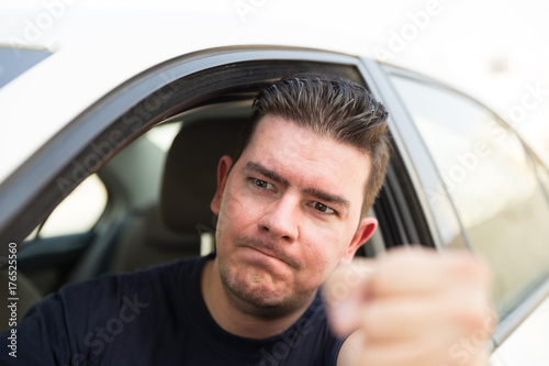 Angry driver pissed off by drivers in front of him and gesturing with hands. Road rage traffic jam concept. 