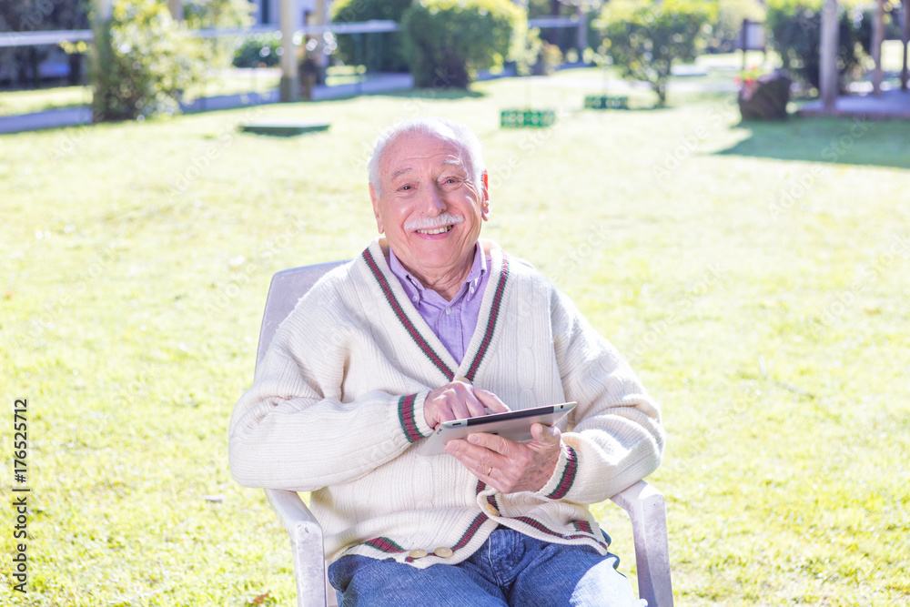 Fototapeta premium Elderly man using tablet outdoor