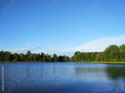 Lake surface at evening in Latvia, East Europe. Landscape with water and forest.