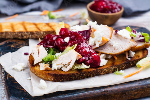Homemade leftover thanksgiving day sandwich with turkey, cranberry sauce, feta cheese and vegetables photo