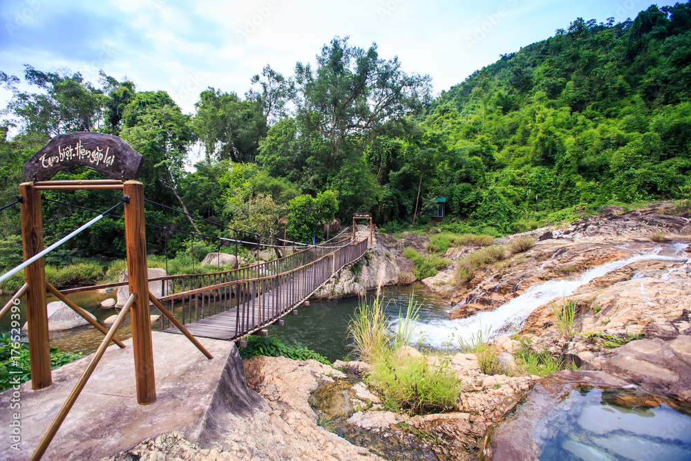 Wooden Bridge with Railings over River at Stones in Park