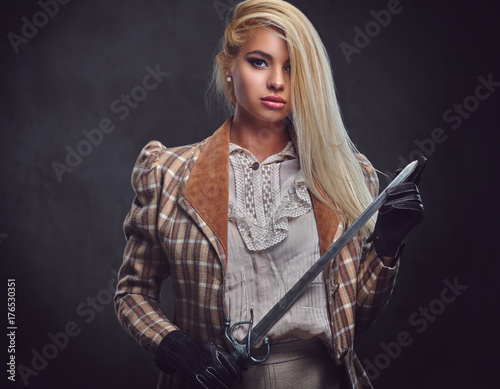 An attractive blonde female holds a silver sword.