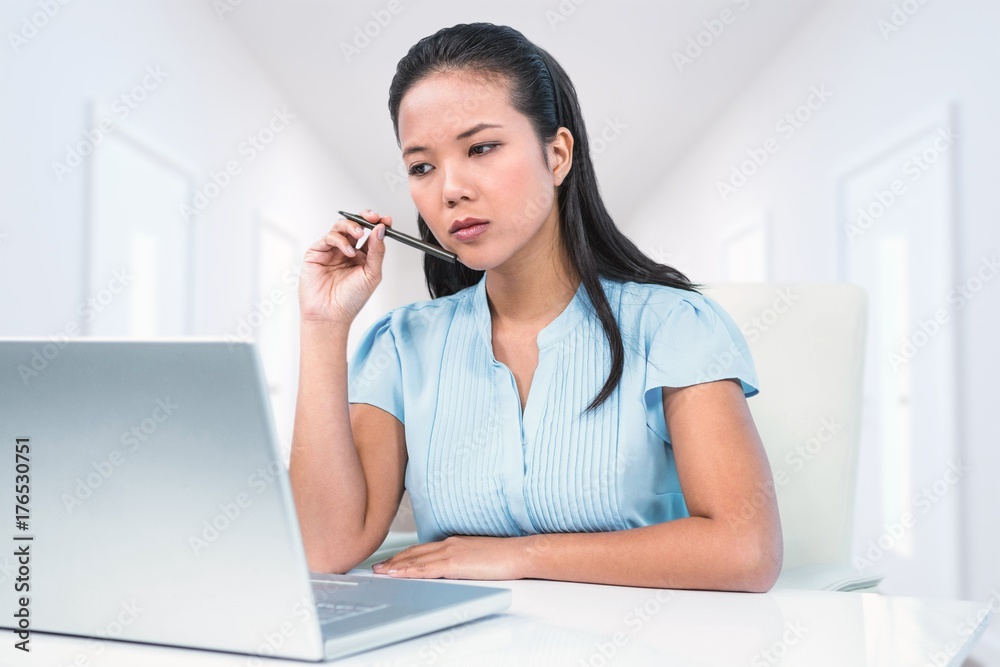 Composite image of thoughtful young businesswoman sitting at her Composite image of thoughtful young businesswoman sitting at her