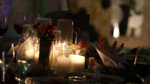 Decorative candles on the dining table, glasses and Christmas candles on the table, white wax candleswith glass candlestick, Candle with Glass Candlestick, restaurant, interior, close-up photo