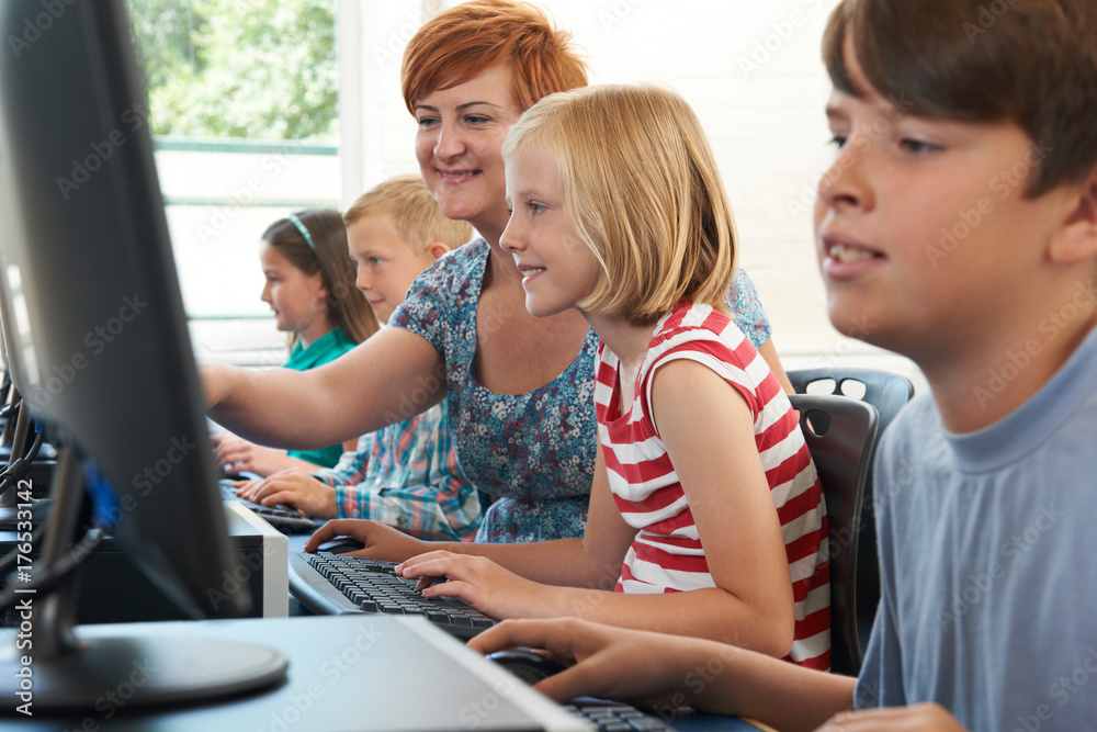 Female Elementary Pupil In Computer Class With Teacher Female Elementary Pupil In Computer Class With Teacher