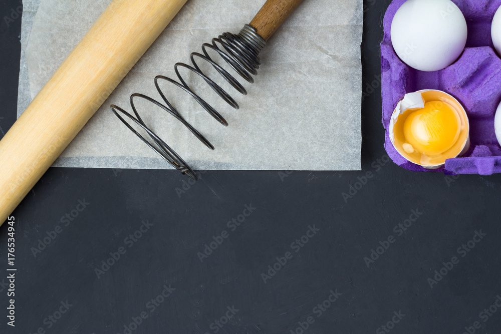 eggs in the tray, accessories for baking: whisk, rolling pin, paper. eggs in the tray, accessories for baking: whisk, rolling pin, paper.