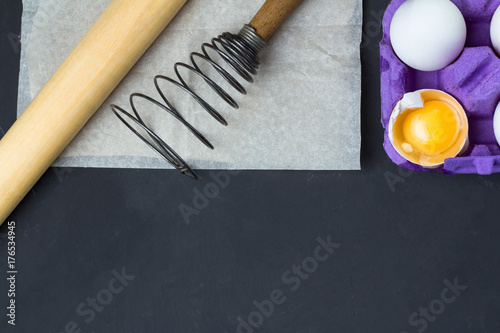 eggs in the tray, accessories for baking: whisk, rolling pin, paper.
