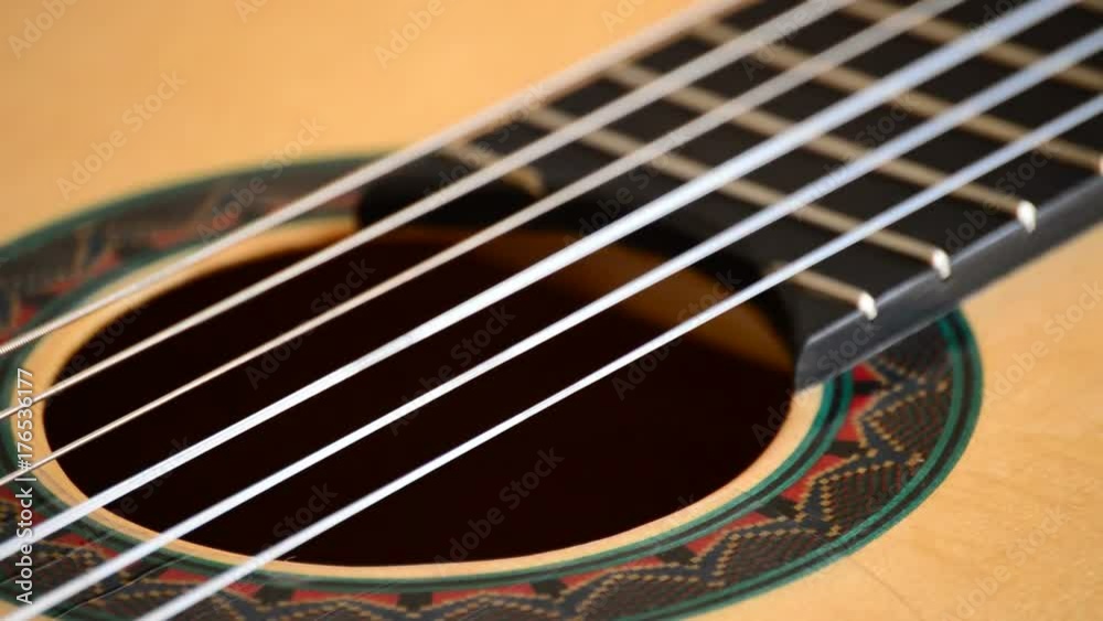 Detail of mouth, strings, frets, body of spanish classic guitar with red mouth rotating at black background