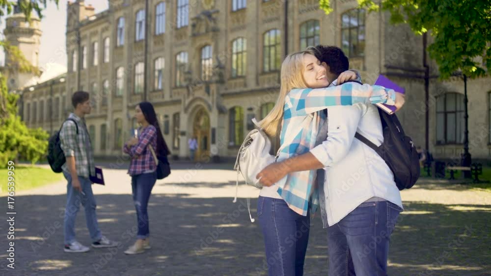 Multiracial classmates embracing, happy to see each other after holidays Multiracial classmates embracing, happy to see each other after holidays