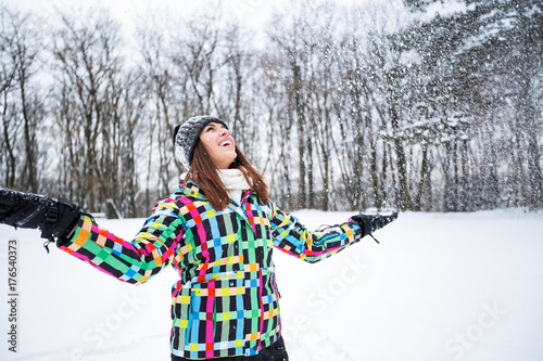 Beautiful smiling woman enjoy at winter day while snow falling