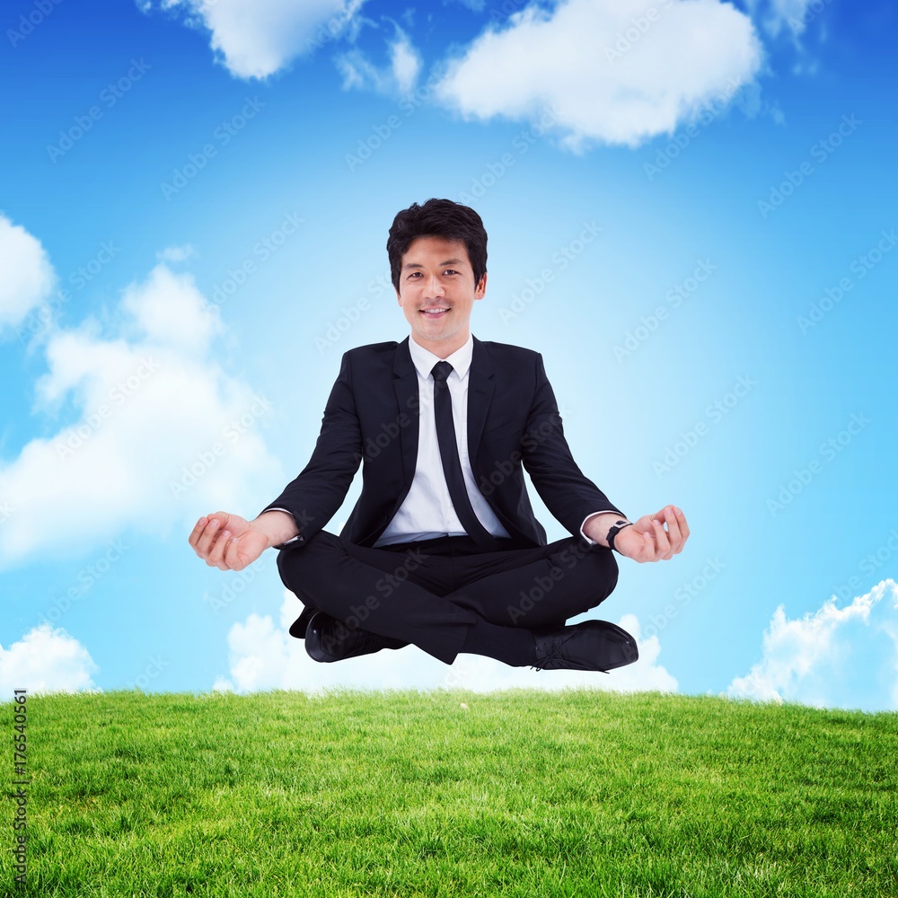 Composite image of businessman sitting with meditation gesture Composite image of businessman sitting with meditation gesture