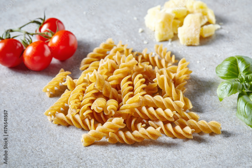 Spaghetti pasta, cheese and vegetables on grey stone table Spaghetti pasta, cheese and vegetables on grey stone table