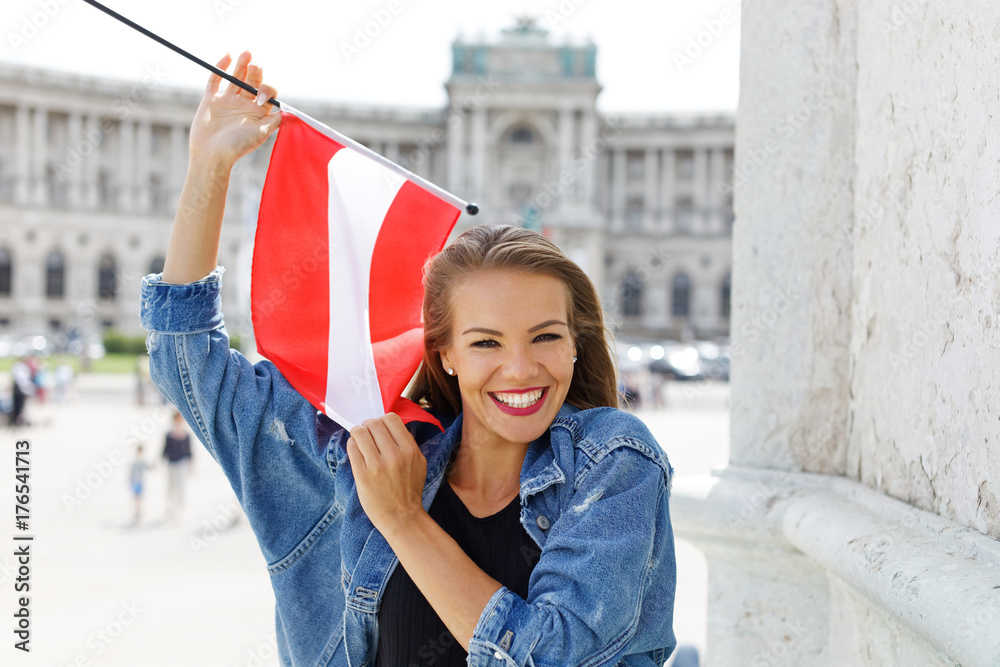 Fototapeta premium Szczęśliwa młoda kobieta trzyma flagę Austrii w Wiedniu