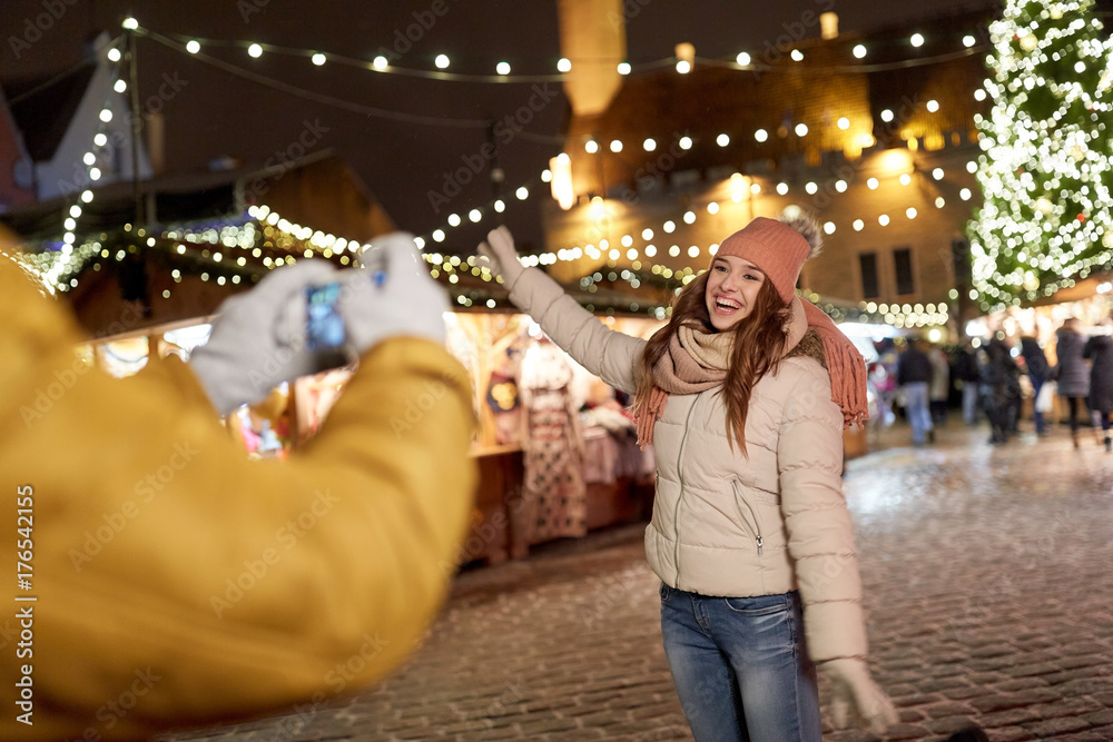 Obraz premium happy woman posing for smartphone at christmas
