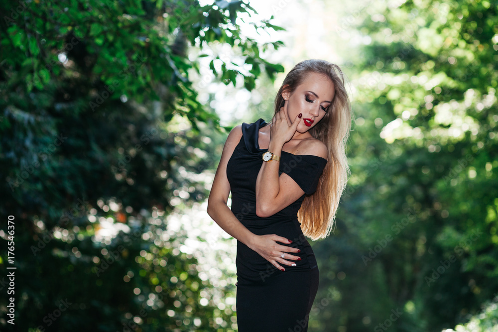 Portrait of beautiful woman in black dress and red lipstick in the park Portrait of beautiful woman in black dress and red lipstick in the park