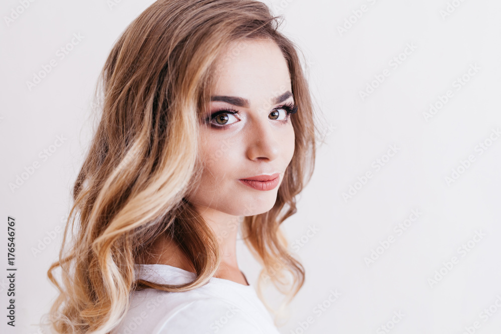 Beautiful woman with evening make-up and curly hair in white T-shirt with word Beautiful woman with evening make-up and curly hair in white T-shirt with word