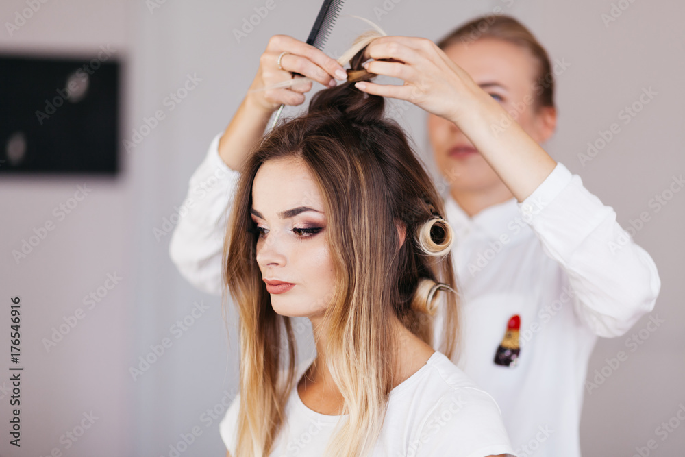 Female hairdresser making hairstyle to brown hair woman in beauty salon Female hairdresser making hairstyle to brown hair woman in beauty salon