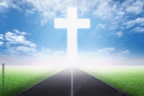 Empty path on the field going to Christian cross