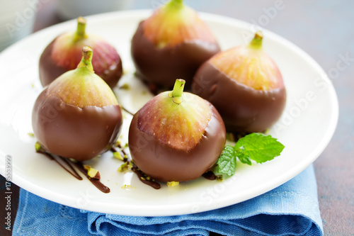 Dessert, fresh figs in chocolate with pistachios.