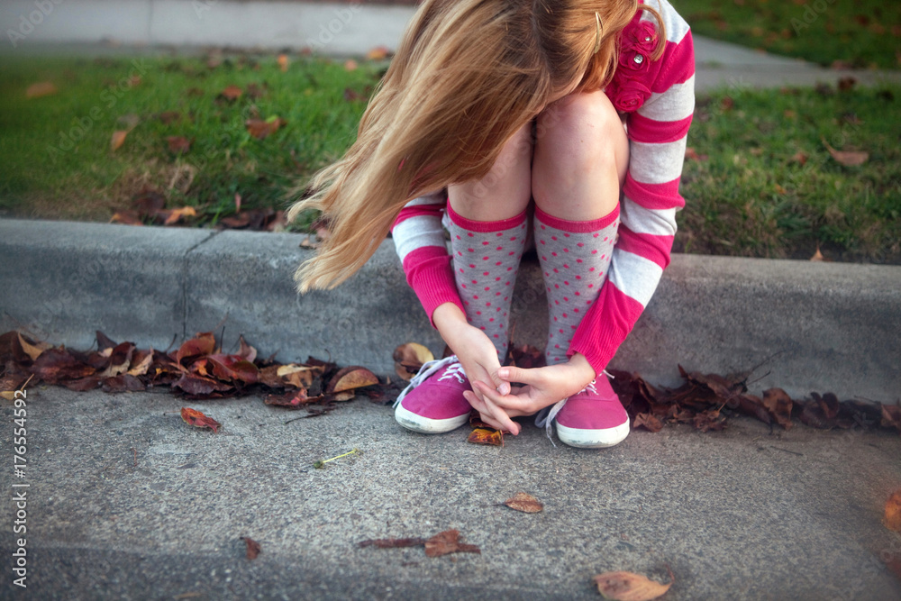 Young Girl Sitting on Sidewalk Hugging Her Knees Stock Photo | Adobe Stock