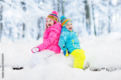 Kids playing in snow. Children play outdoors in winter snowfall.